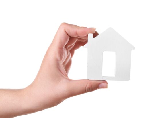 Female hand with small model of house isolated on white